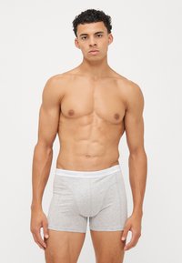 Boxeri din bumbac gri cu un elastic alb pe care este inscriptionat "BJÖRN BORG", având un design ajustat și o textură moale.