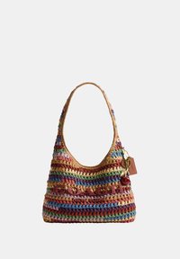 Sac à bandoulière Coach tissé coloré avec une poignée arrondie et un porte-clés en forme de cerise sur fond blanc.