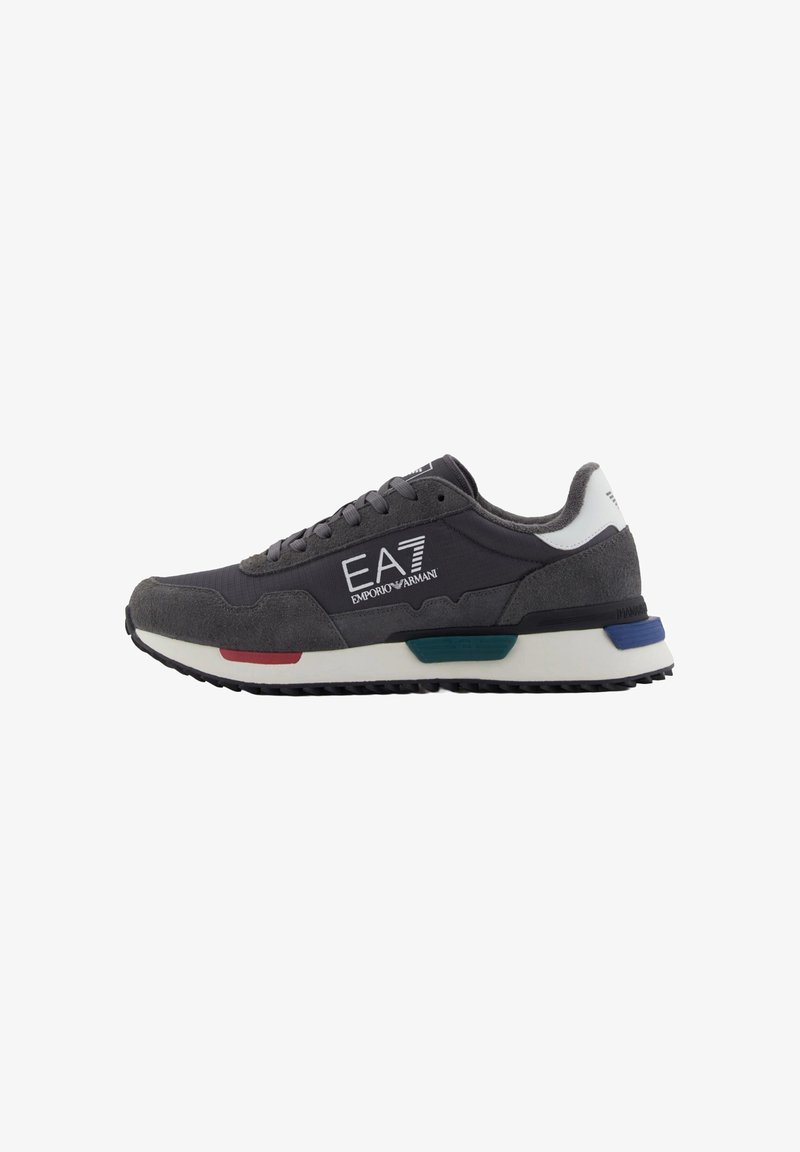 Sneaker sportive grigie con tomaia in suede e tessuto, dotate di un logo bianco, accenti multicolore e suola in gomma nera testurizzata.