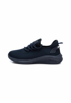 Zapatilla deportiva de color azul marino con parte superior de malla texturizada, suela de goma gruesa y cordones prominentes. Presenta un logo contrastante en el talón.