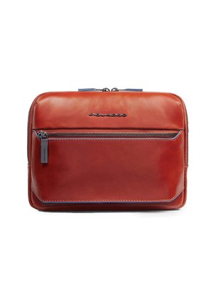 Sac en cuir d'un riche marron rougeâtre avec une texture lisse. Dispose d'une poche zippée à l'avant, d'accents bleus et d'un logo de marque en argent. Forme rectangulaire.