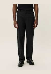 Black tailored trousers with a straight leg design, made from smooth fabric. Features a button closure and belt loops, paired with black shoes.