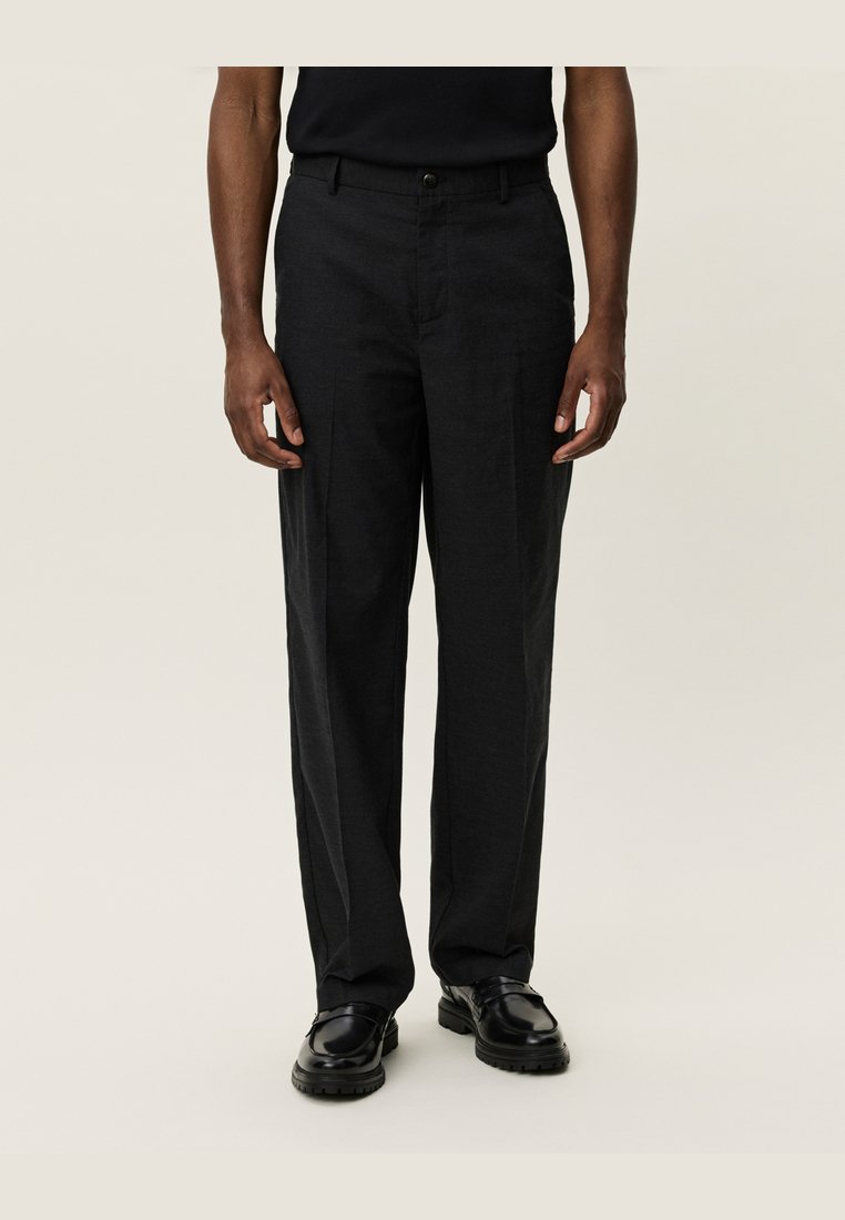 Black tailored trousers with a straight leg design, made from smooth fabric. Features a button closure and belt loops, paired with black shoes.