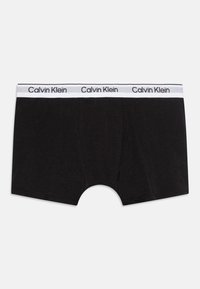 Čierne boxerky vyrobené z mäkkého materiálu s bielym pásom s logom Calvin Klein a klasickým plochým predným dizajnom.