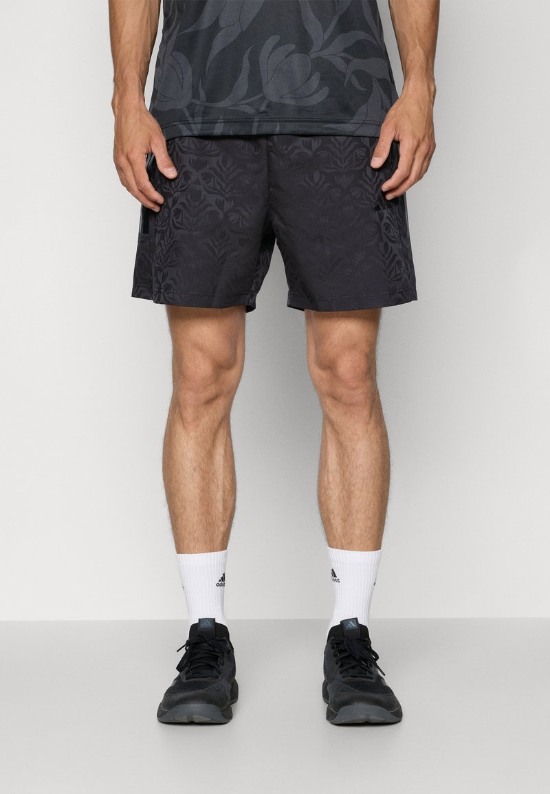 Black athletic shorts with a subtle floral pattern, paired with black shoes and white socks. The design is lightweight and fitted.