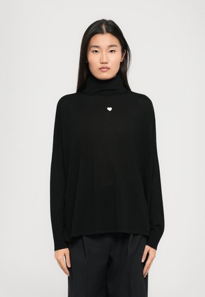 Black turtleneck sweater made of soft fabric, featuring a small white heart emblem on the chest and a relaxed, oversized fit.