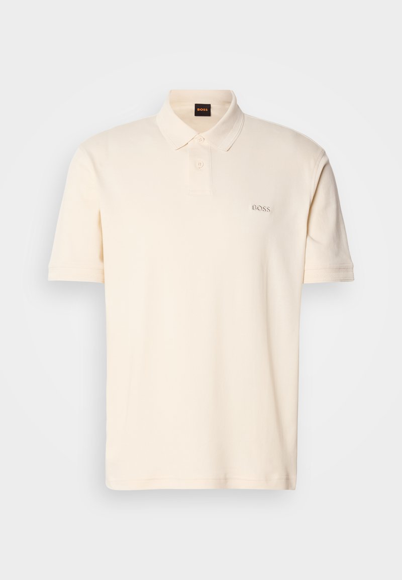 Polo shirt de couleur crème en coton, avec une patte de boutonnage à deux boutons et un petit logo brodé "BOSS" sur la poitrine gauche. Manches courtes.