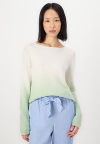 Pull long à manches longues léger avec un dégradé de crème à vert menthe, doté d'une coupe décontractée et d'un tricot texturé. Assorti à un pantalon bleu doux.