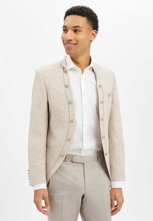 Hellbeige Jacke mit einer strukturierten Oberfläche und fünf Knöpfen. Kombiniert mit einem weißen Hemd und hellgrauen Hosen; verfügt über einen strukturierten Kragen und eine taillierte Passform.