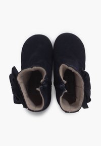 Botines de ante azul marino oscuro con suave forro beige, que cuentan con un lazo decorativo en el lateral y un cierre con cremallera para facilitar su uso.