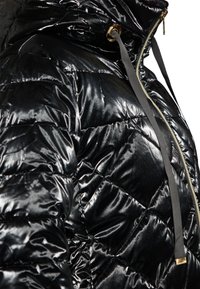 Jachetă puffer neagră cu un finisaj lucios. Are o textură cu model în diamond, glugă, accesorii aurii și un șnur gri contrastant.