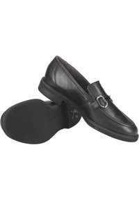 Zwarte leren loafers met een gladde afwerking, voorzien van een decoratieve zilveren gesp en een gestructureerde zwarte rubberen zool. Klassiek, instapontwerp.