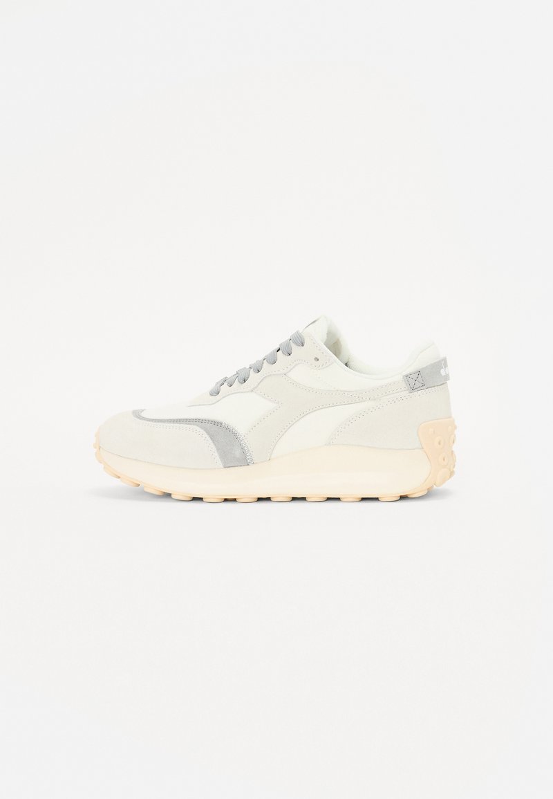 White athletic shoes with grey accents, smooth and suede textures, round toe, lace-up design, and a light beige rubber outsole.