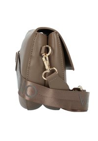 Brun konstläder crossbody-väska har en slank form, guldhardware och en bred axelrem med "VAN" tryckt i silver.