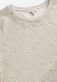 Beige spidsbluse med rund halsudskæring, prydet med intrikate blomster mønstre og et tekstureret, gennemsigtigt stof. Mærke: Cellbes, størrelse 38/40.