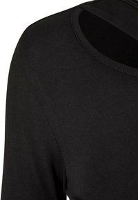 Schwarzes Langarmoberteil mit rundem Ausschnitt, ausgestattet mit einem Ausschnitt-Design an der Schulter, aus einem glatten, mitt schwerem Stoff gefertigt.