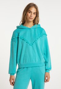Felpa con cappuccio turchese in tessuto morbido. Presenta un design a chevron con dettagli a pom-pom lungo il collo e una vestibilità comoda.
