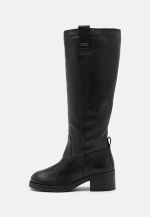 Bottes en cuir noir à hauteur de genou, avec un bout arrondi, un talon carré et un logo sur la languette. Comportent des coutures discrètes et une texture lisse.