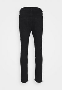 Jeans de mezclilla negra, corte ajustado, con cinturilla estándar, diseño de cinco bolsillos y costuras discretas en las costuras.