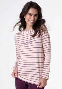 Maglietta a maniche lunghe rosa chiaro con strisce orizzontali viola scuro, collo a scialle e la parola "amabile" ricamata in una tonalità corrispondente.