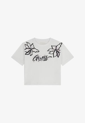 White short-sleeve t-shirt featuring black floral designs on shoulders and "Guess" text in a stylized script at the center. Cotton material.