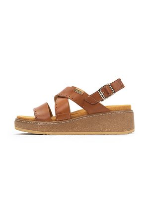 Sandalia de cuero marrón con dos correas anchas, hebilla ajustable y suela de corcho gruesa. Presenta costuras en contraste y una superficie texturizada.