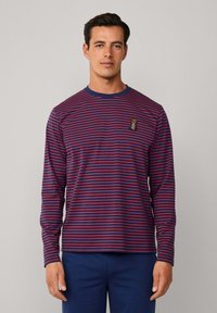 Camisa de manga larga a rayas en azul oscuro y rojo, con un cuello redondo y un pequeño detalle bordado en el pecho. Textura de tela suave.