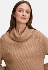 Beiger, gestrickter Pullover mit hohem, umgeschlagenem Schalkragen und gerippter Textur. Verfügt über eine lässige Passform und abfallende Schulternaht.