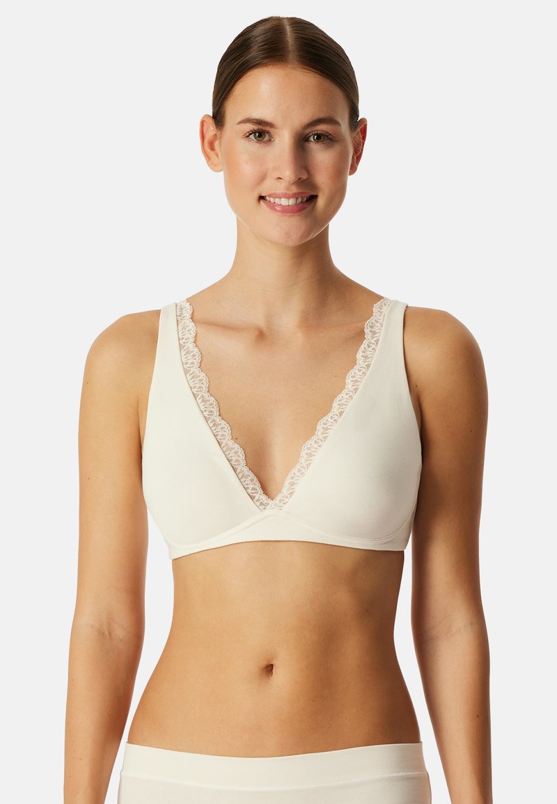 Bralette suave en color crema con detalles de encaje, diseño de cuello en V profundo y tirantes anchos. Tejido suave con una silueta minimalista y sin costuras.