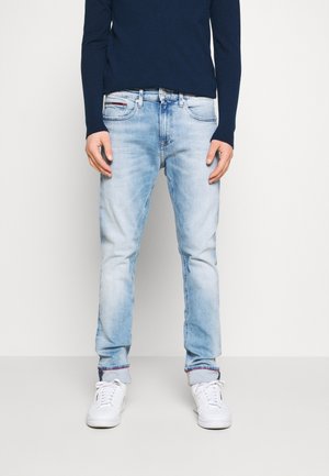 Hellblaue Jeans im Slim-Fit-Schnitt mit leichter Ausbleichung, fünf Taschen und umgeschlagenen Säumen, die ein rot-blau gestreiftes Innenfutter zeigen.