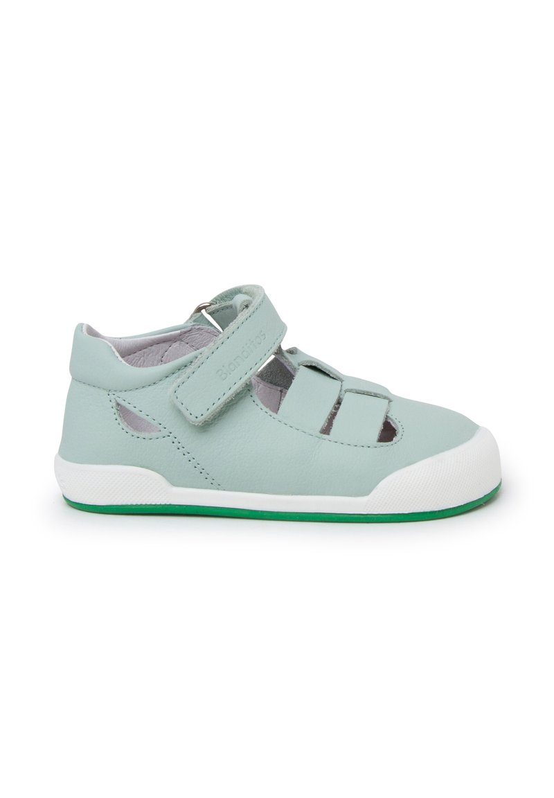 Sandal de cuero azul claro con diseño abierto, tira de Velcro, suela de goma blanca, acentos verdes y recortes laterales para transpirabilidad.