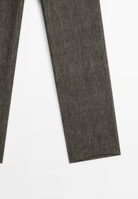 Partie inférieure d’un pantalon droit gris foncé sur fond blanc, montrant la texture du tissu et des ourlets nets.