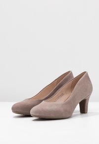 Escarpins en daim gris avec un bout arrondi et un talon bloc de hauteur moyenne, présentant une texture lisse et un design épuré et simple.