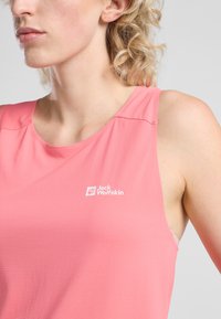 Top senza maniche rosa realizzato in tessuto testurizzato, con scollatura rotonda e un logo bianco sul petto. Nessun motivo o accento visibile.