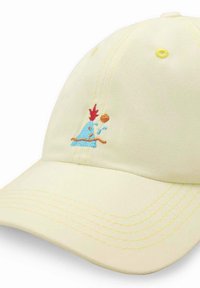Żółta bawełniana czapka z żółtym szwem i małym haftem przedstawiającym niebieską postać z czerwonymi akcentami i brązową linią.