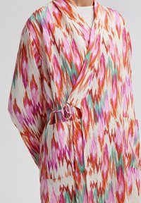 Vícebarevný kimono s odvážným ikat vzorem v růžové, oranžové a zelené barvě. Vyrobeno z lehkého materiálu s překrývací konstrukcí a kapsami.