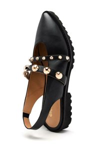 Scarpa di pelle nera con punta affilata, suola in gomma spessa e doppie cinghie con dettagli metallici rotondi sulla parte anteriore.