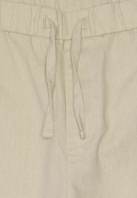 Beige Leinen-Shorts mit einem elastischen Bund, ausgestattet mit einem Kordelzug und seitlichen Nähten. Der Stoff hat eine strukturierte Oberfläche.