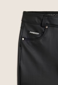 Pantaloni stretch neri con un finish liscio e opaco. Presentano dettagli in metallo argentato, cuciture decorative e una piccola tasca frontale con il nome del marchio "Freddy."