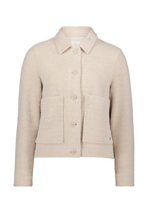 Giacca beige testurizzata realizzata in tessuto a trama. Presenta un colletto, chiusura frontale con bottoni, due grandi tasche applicate e maniche lunghe.