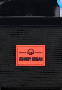 Svart texturerat material med en gummiband orange etikett med "JOHNNY URBAN" i svart text. Framträdande med en blank finish och blå accenter.