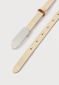 Złota skórzana opaska z metalowym zapięciem w kolorze srebrnym i wieloma otworami do regulacji. Gładka tekstura i minimalistyczny design.