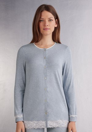 Lichtblauwe lange mouwen cardigan met een ronde halslijn, voor knopen en witte kantafwerking aan de onderrand. Zachte stof met een gestructureerde uitstraling.