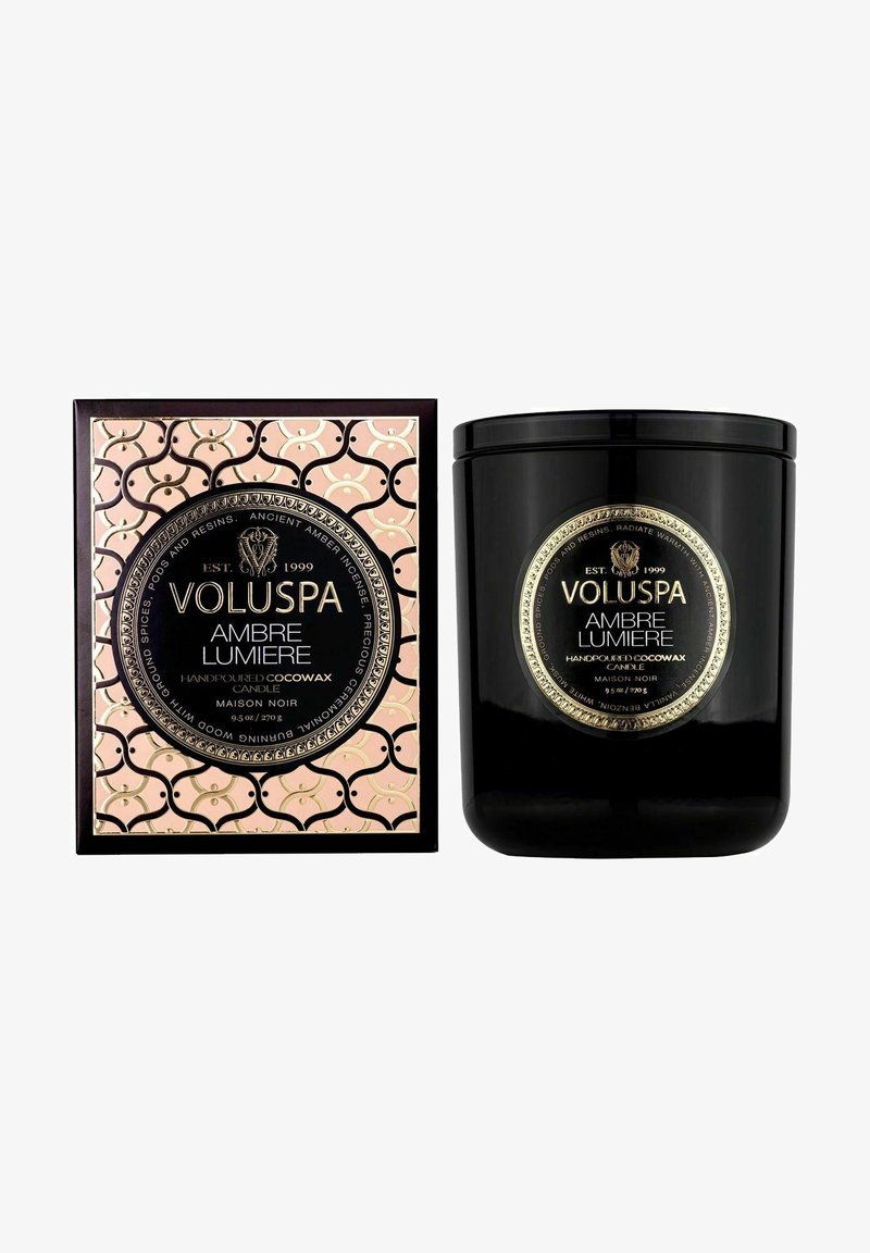 Sort lys i en blank beholder med en guld label. Kommer i en pink æske med et gentagende mønster og prægede guldaccenter.