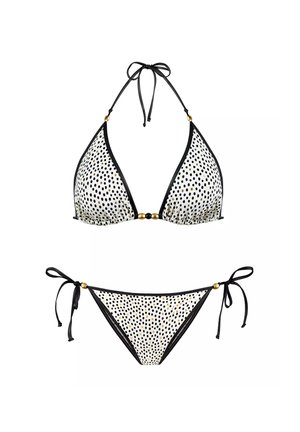 Zestaw bikini w białym kolorze w czarne kropki, z trójkątnym stanikiem z czarnym wykończeniem i złotymi akcentami oraz dopasowanym dołem z wiązanymi bokami.