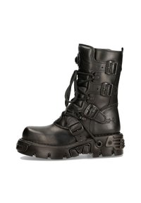 Bottines noires en cuir à lacets avec plusieurs boucles réglables, semelle texturée robuste, bout rond et accents en matériel décoratif.