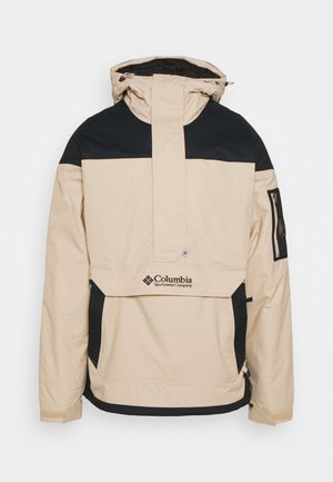 Veste à capuche beige et noire Columbia Sportswear avec poche à rabat sur le devant et poche zippée sur la manche, conçue pour une utilisation en extérieur.