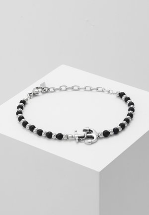 Black beaded bracelet featuring silver anchor charm, alternating glossy beads, and chain links. Smooth texture with shiny accents.
