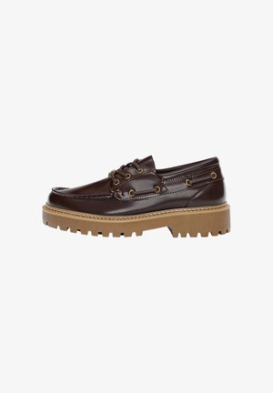 Brown leather boat shoe with textured finish, featuring gold hardware accents, a thick tan rubber sole, and a classic lace-up design.