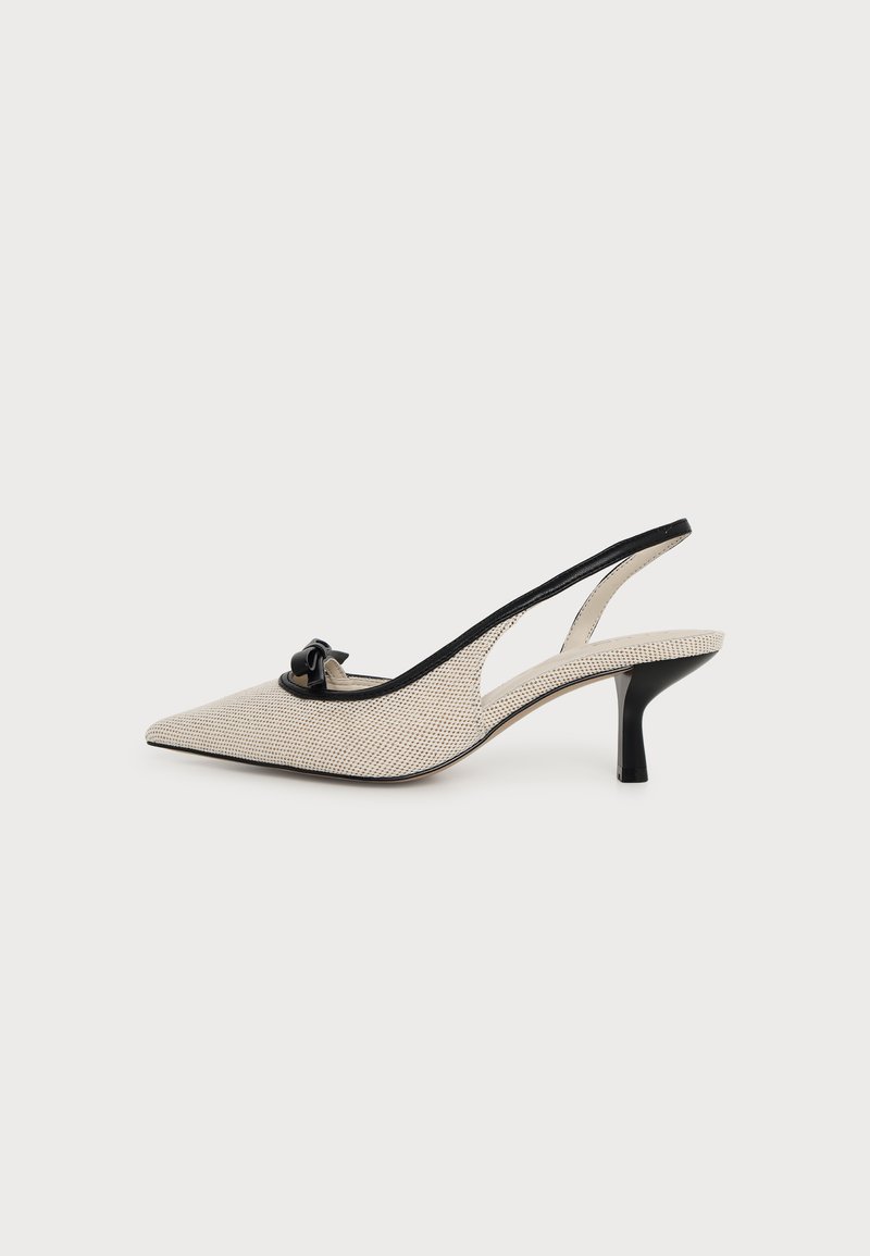 Escarpin slingback beige à bout pointu avec bordure noire, détail nœud sur le devant et talon fin noir sur fond blanc uni.